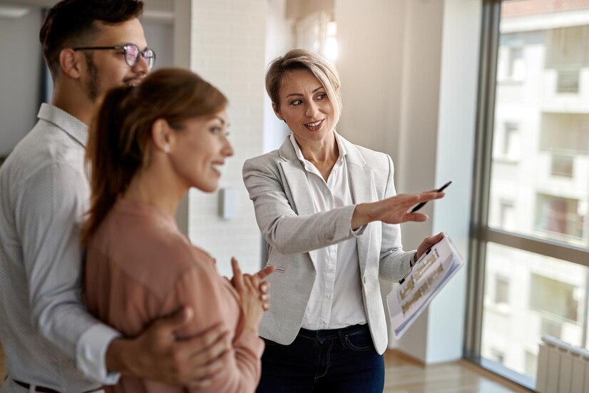 smiling-real-estate-agent-talking-with-couple-interested-buying-new-home_637285-6081
